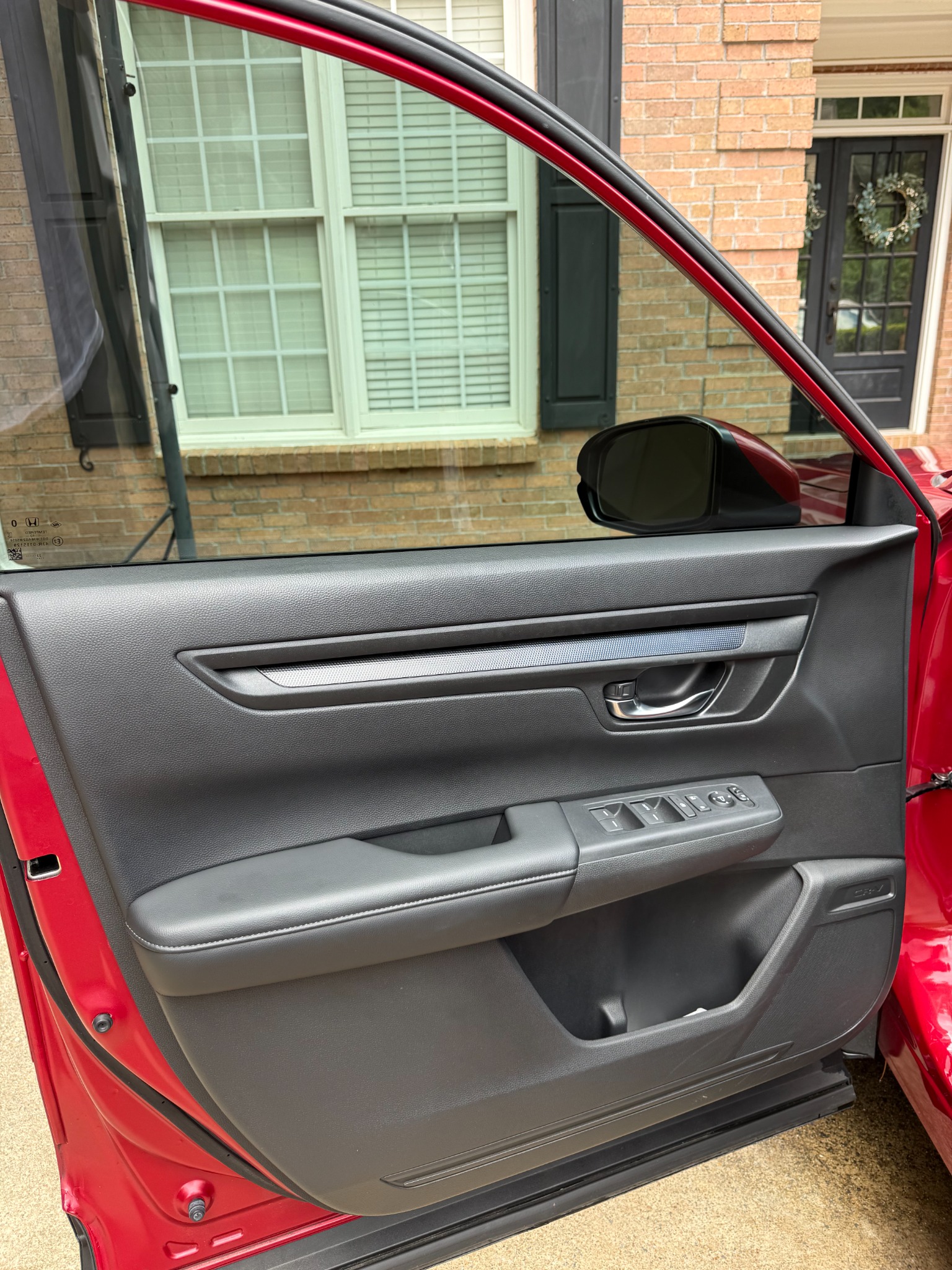 Clean red Honda interior door panel after detailing